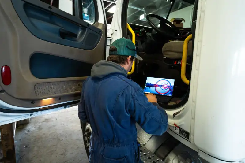 Diesel mechanic performing diagnostics on a truck engine at Houston Performance Diesel.